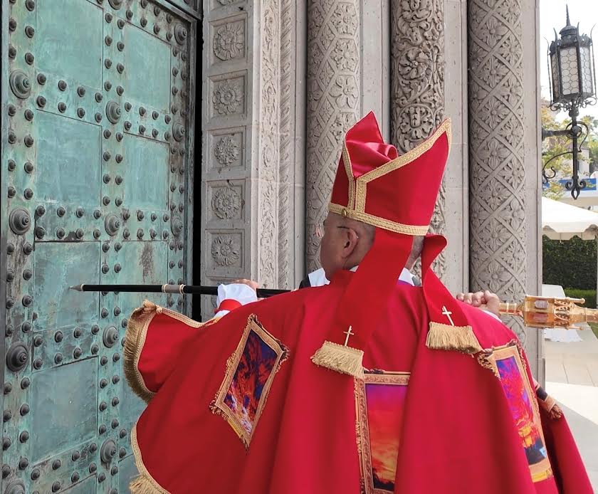 Bishop Antonio José Gallardo Lucena knocks on St. John’s Cathedral doors before his installation.